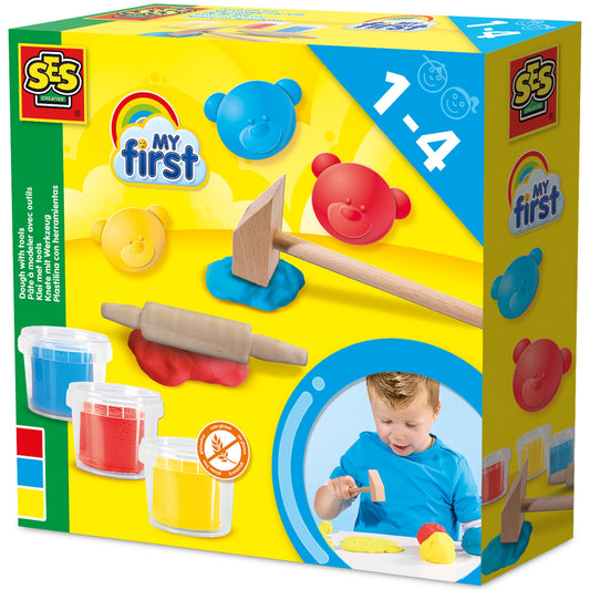 SES Creative My First Dough Set packaging showing red, blue, and yellow dough balls, wooden hammer, rolling pin, and dough tools, modeled by a child on box fron