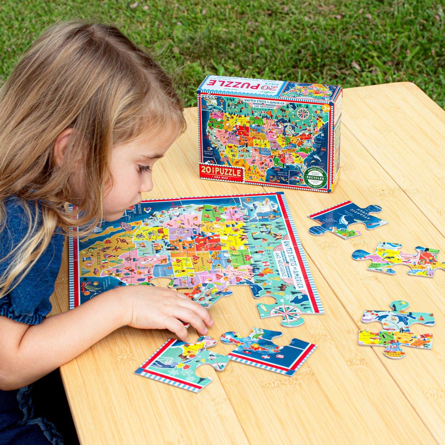 Child assembling colorful USA Map 20 Piece Puzzle on wooden table