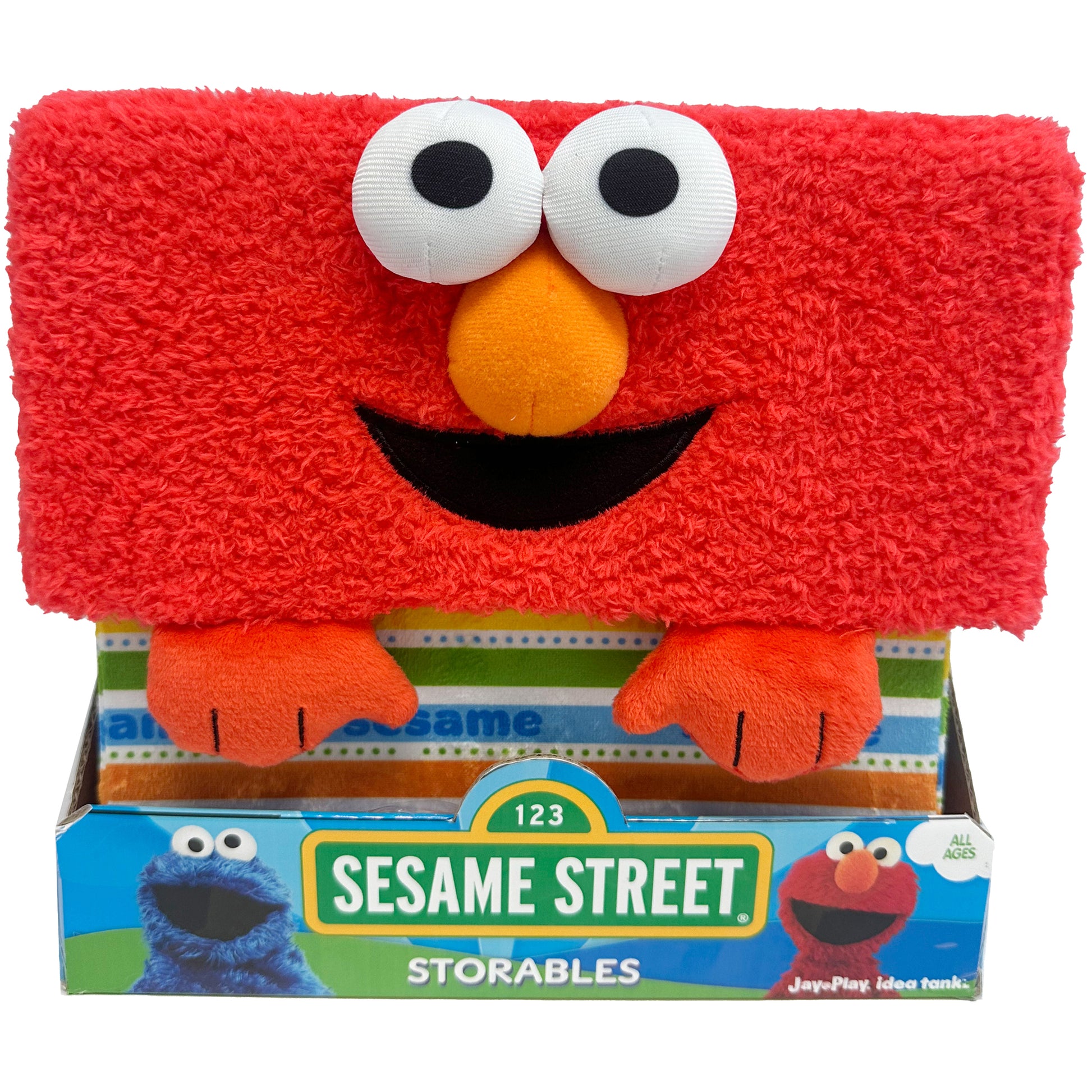 Sesame Street Elmo Storables fabric storage bin, red plush with white eyes, orange nose, black smile, and orange paws, shown in packaging