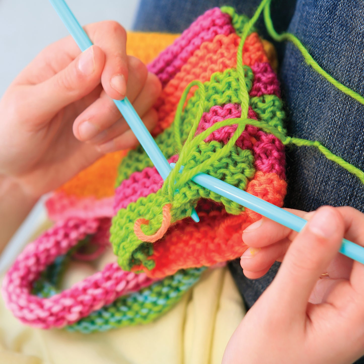 Easy-To-Do Knitting toy with colorful pink, green, and orange knitted fabric and blue needle