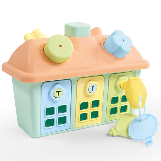 Pastel cottage-shaped toy with green windows, yellow door, peach roof, and removable shape-sorting pieces in yellow, blue, and green