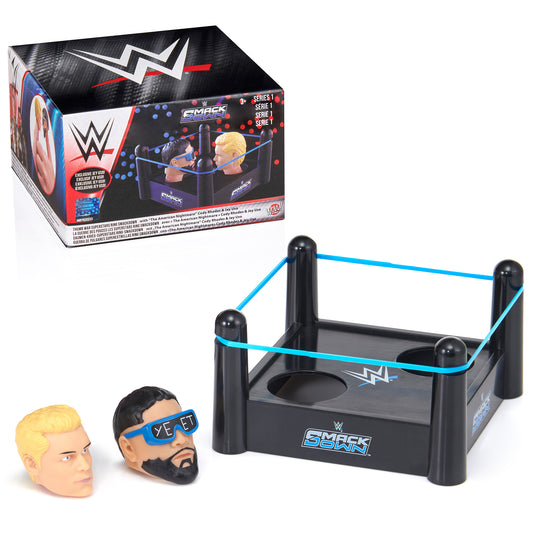 WWE Thumb War playset with black arena featuring blue ropes, two interchangeable wrestler head figures with blonde and dark hair, and blue eye mask accessory