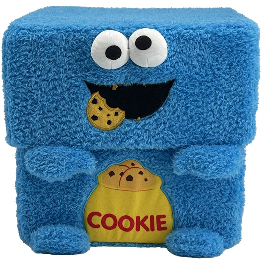 Blue plush cube storage bin with Cookie Monster face, white eyes with black pupils, open mouth smile, and yellow cookie pouch pocket labeled COOKIE