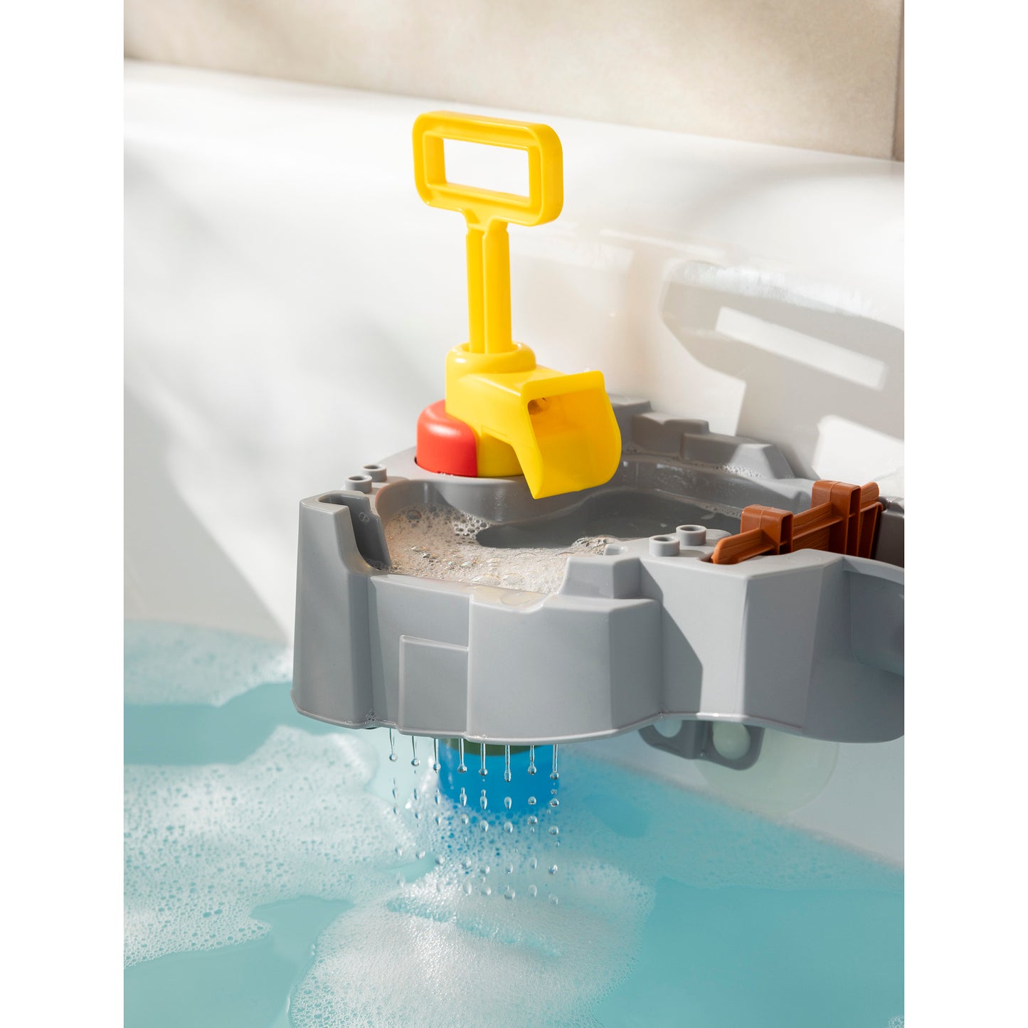 AquaPlay Sploshy Mountain yellow shovel toy in bathwater with gray mountain base
