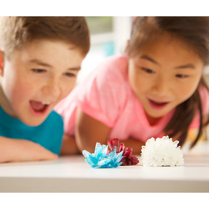 4M Crystal Growing Kit with blue, red, and white crystals displayed as two children observe them