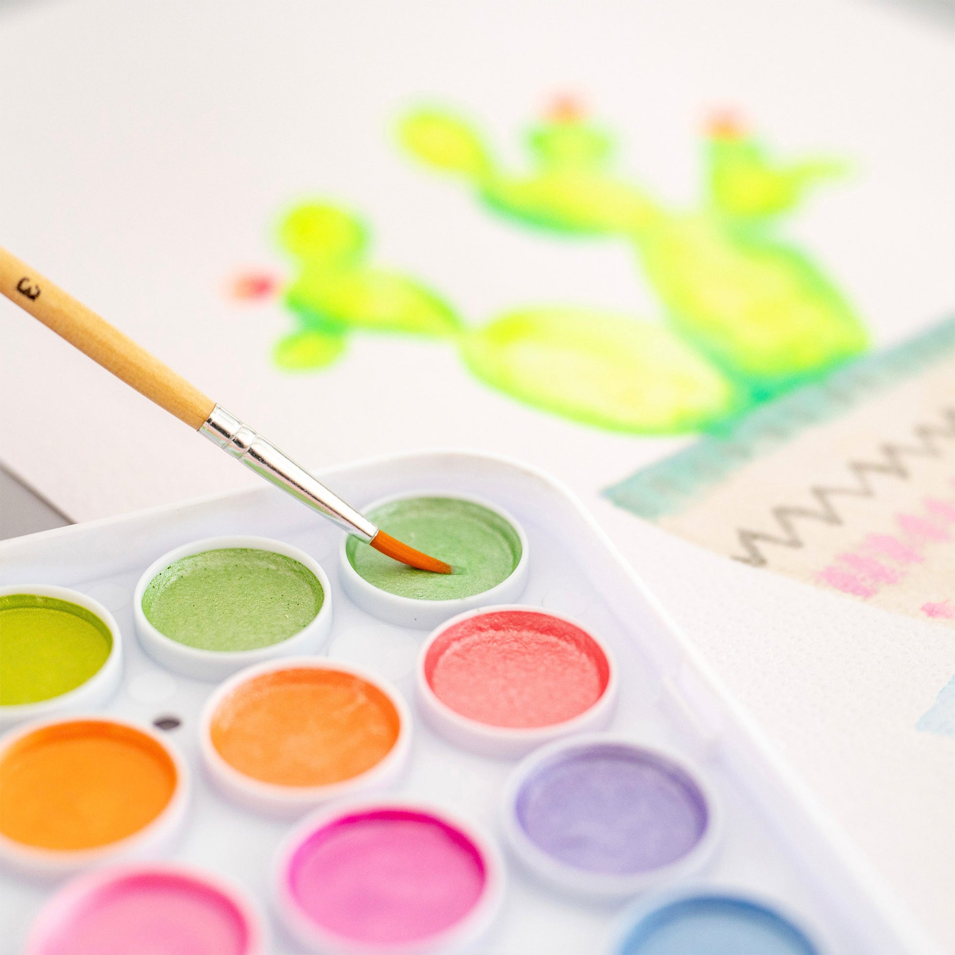 Essential Watercolor Paint Set with neon and metallic colors, brush, and cactus painting