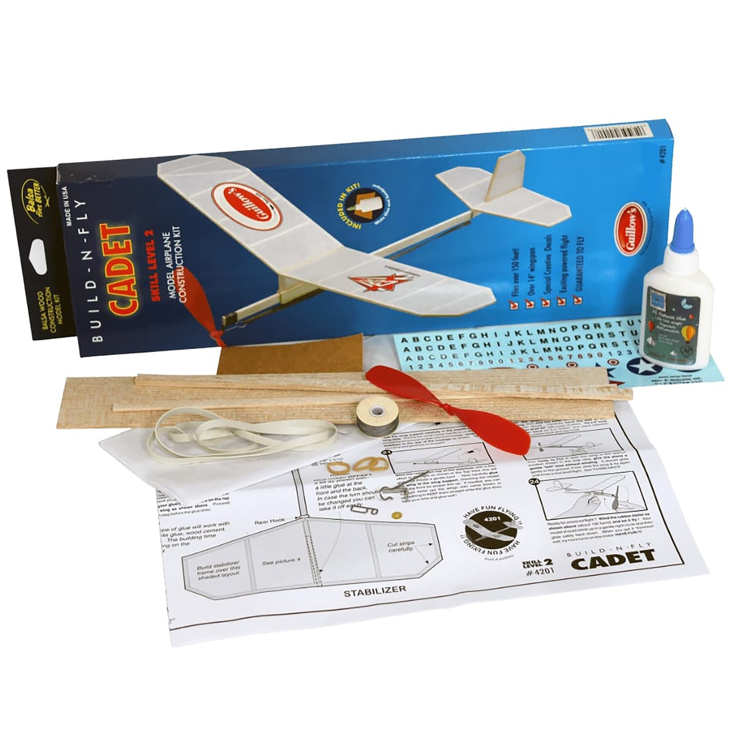 Build-N-Fly Cadet model airplane kit with white foam plane, wood pieces, instructions, and assembly tools