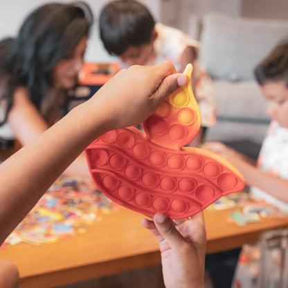 Diwali Burst Fidget Toy in red and yellow, pop-it sensory toy held by child