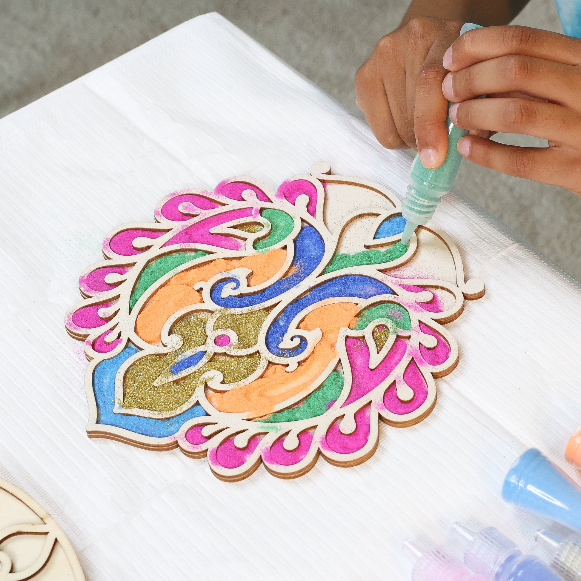 Make Your Own Wooden Rangoli craft kit with colorful painted pieces in pink, blue, green, and gold