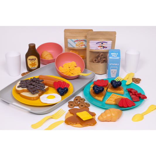 Breakfast Delights play set with toy food including waffles, pancakes, cereal, toast, eggs, and fruit on colored plates, yellow utensils, maple syrup bottle, mi
