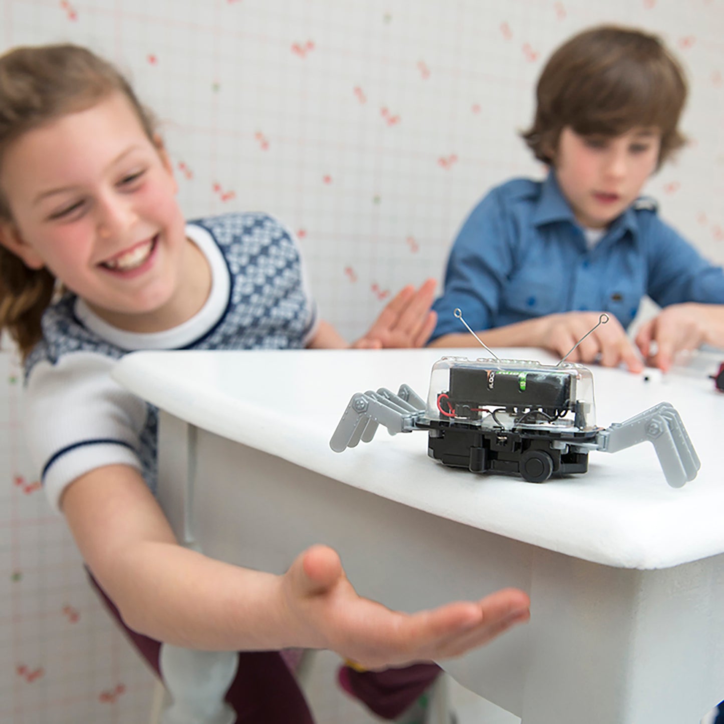 KidzRobotix Table Top Robot with gray claw arms and antenna, kids playing