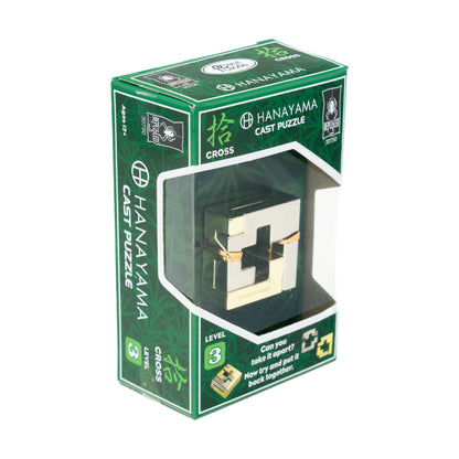 Hanayama Level 3 Cast Puzzle - Cross in green packaging with cream and black metal puzzle cube visible through window