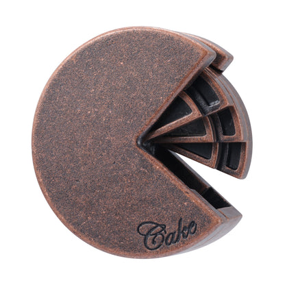 Copper-colored metal puzzle shaped like a slice of cake with interlocking segments, branded Hanayama