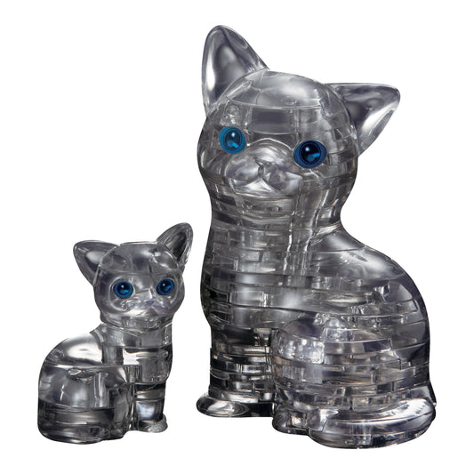 Two transparent black crystal puzzle cat figurines with blue eyes, smaller kitten and larger adult cat side by side