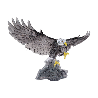 Bald eagle figurine with white head, black body and wings, yellow beak and talons, mounted on gray rocky base