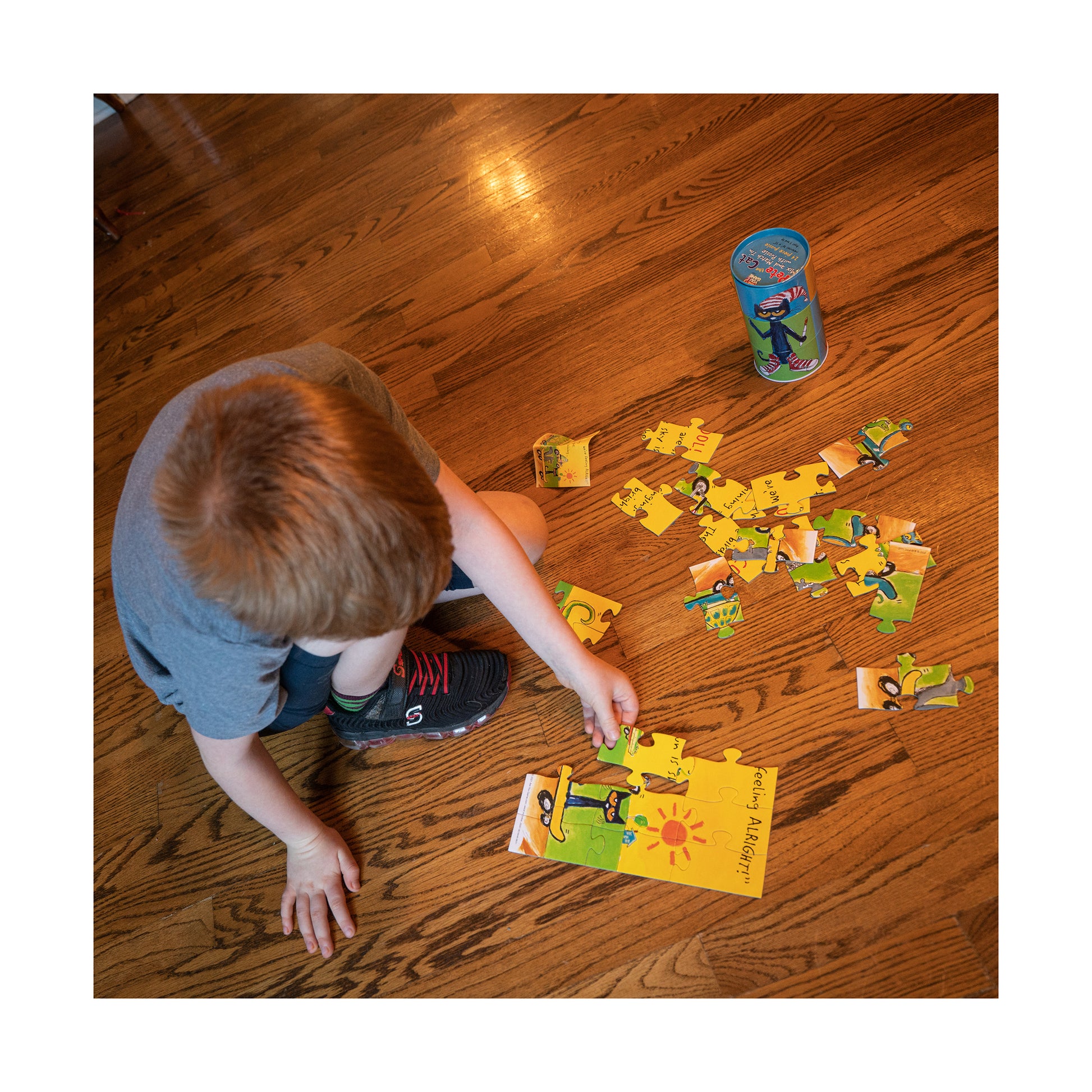 Pete the Cat Mix and Match 24-Piece Tin Puzzle with yellow and green pieces displayed on wooden floor