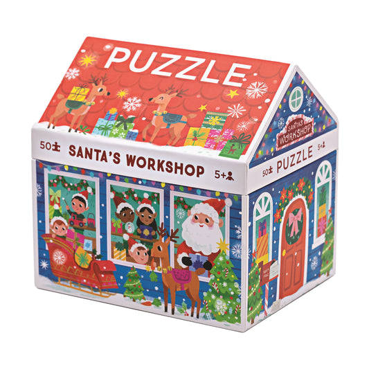 Santa's Workshop house-shaped 50-piece jigsaw puzzle with red roof, featuring Santa, elves, reindeer, Christmas trees, and holiday decorations on blue and red w