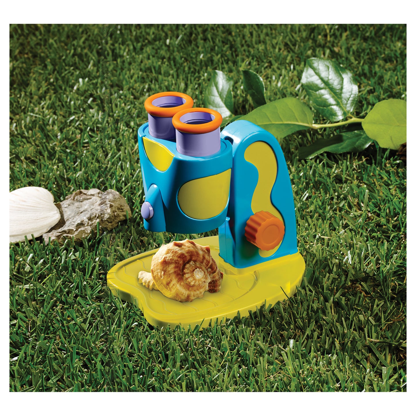 GeoSafari Jr. STEM Microscope with blue and yellow body, orange eyepieces, and LED light outdoors