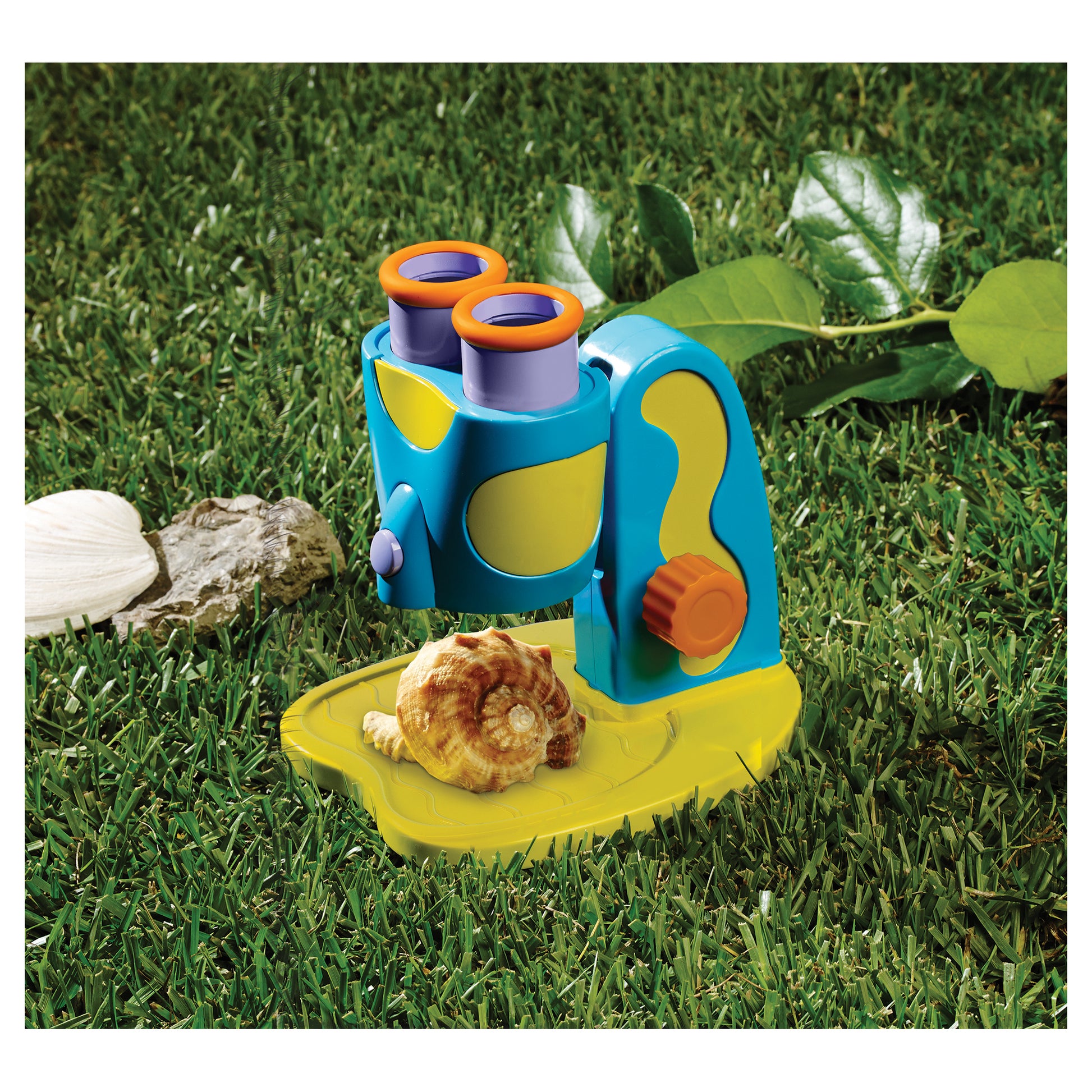 GeoSafari Jr. STEM Microscope with blue and yellow body, orange eyepieces, and LED light outdoors