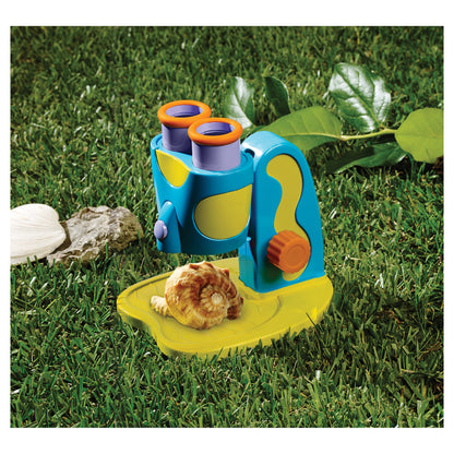 GeoSafari Jr. STEM Microscope with blue and yellow body, orange eyepieces, and LED light outdoors