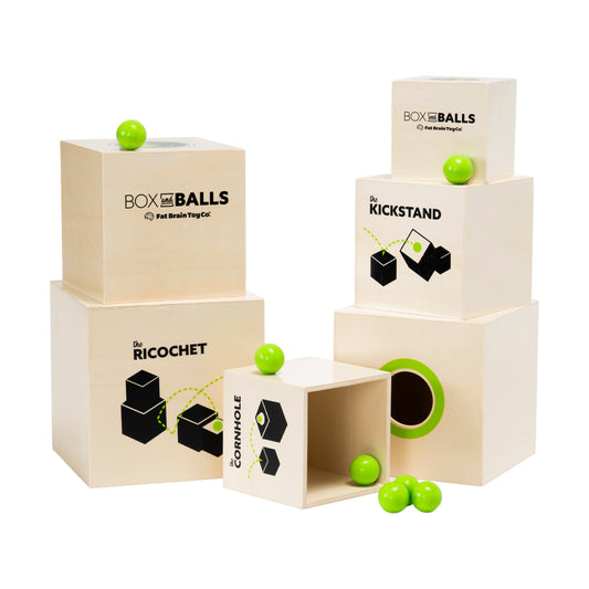 Box and Balls wooden trick shot game set with natural wood boxes labeled Ricochet, Kickstand, and Corryhole, featuring bright green balls and black illustrated