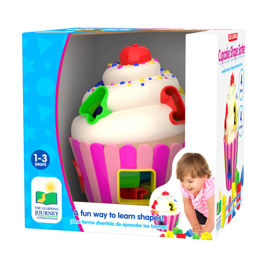 Cupcake Shape Sorter toy with white frosting, colorful sprinkles, red cherry top, and pink ridged base with shape-sorting slots, modeled by a toddler