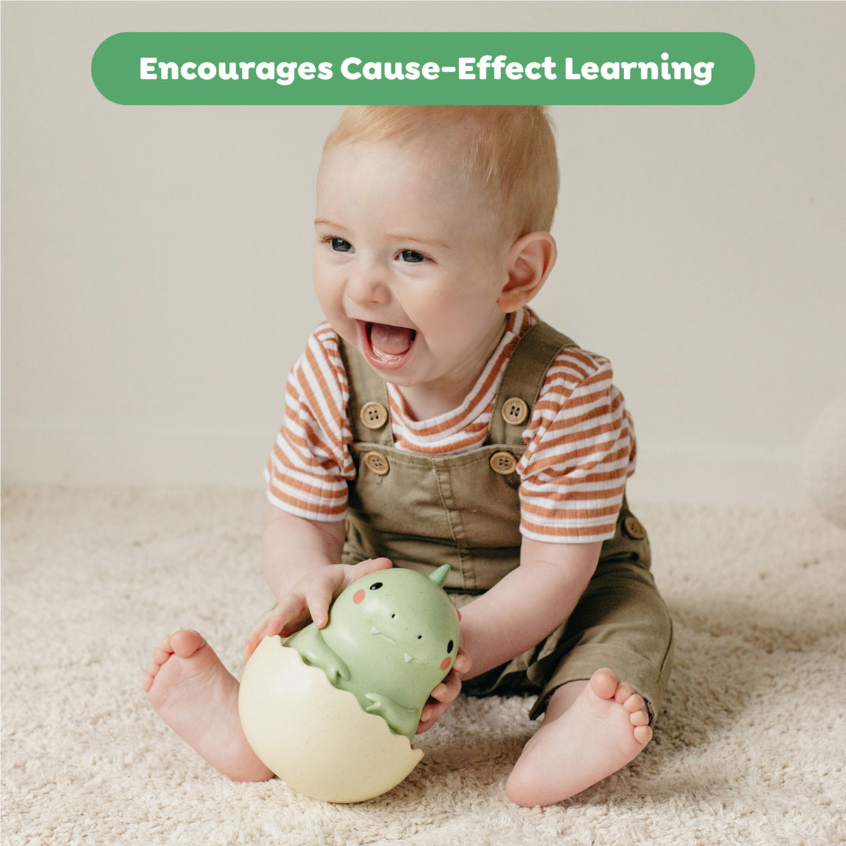 Tiger Tribe Roly Poly Dino Toy in green and cream, baby playing with sensory toy