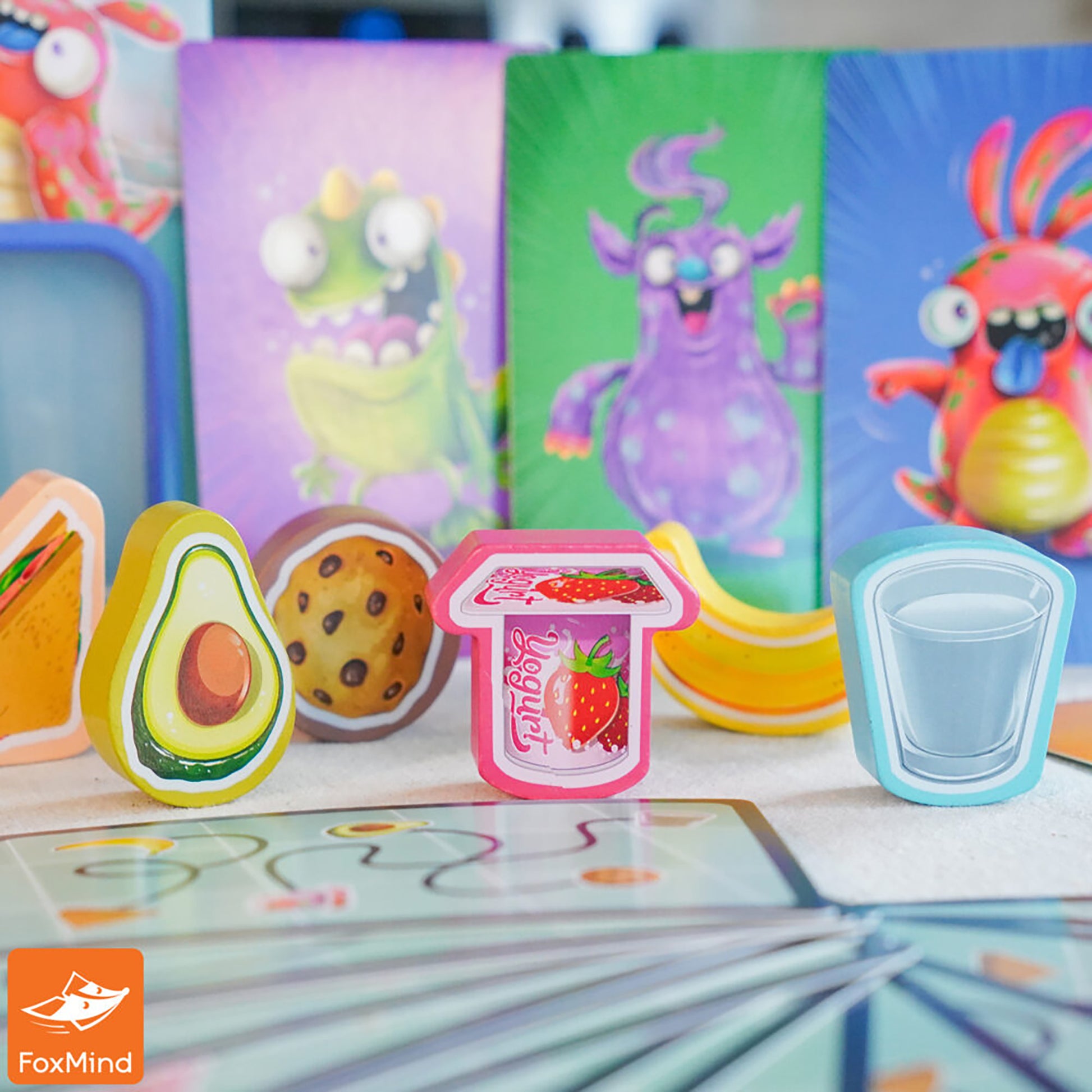 Lunch Crunch card game with colorful food tokens including avocado, cookie, banana, strawberry jam, and water glass