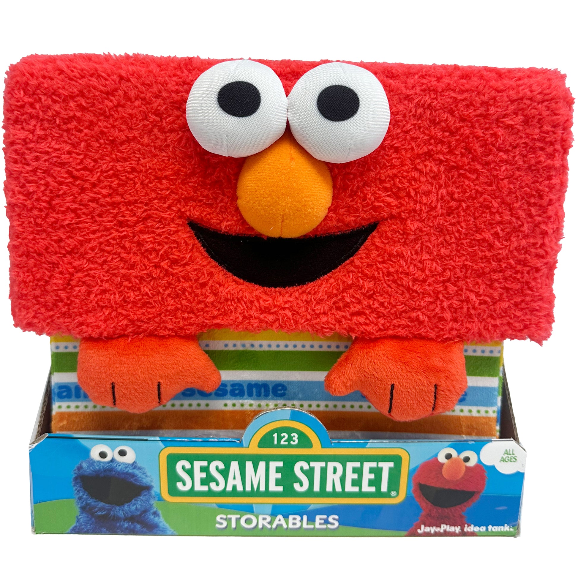 Sesame Street Storable Elmo plush cube, red fuzzy body with large white eyes, orange nose, black smile, and orange arms, shown in packaging