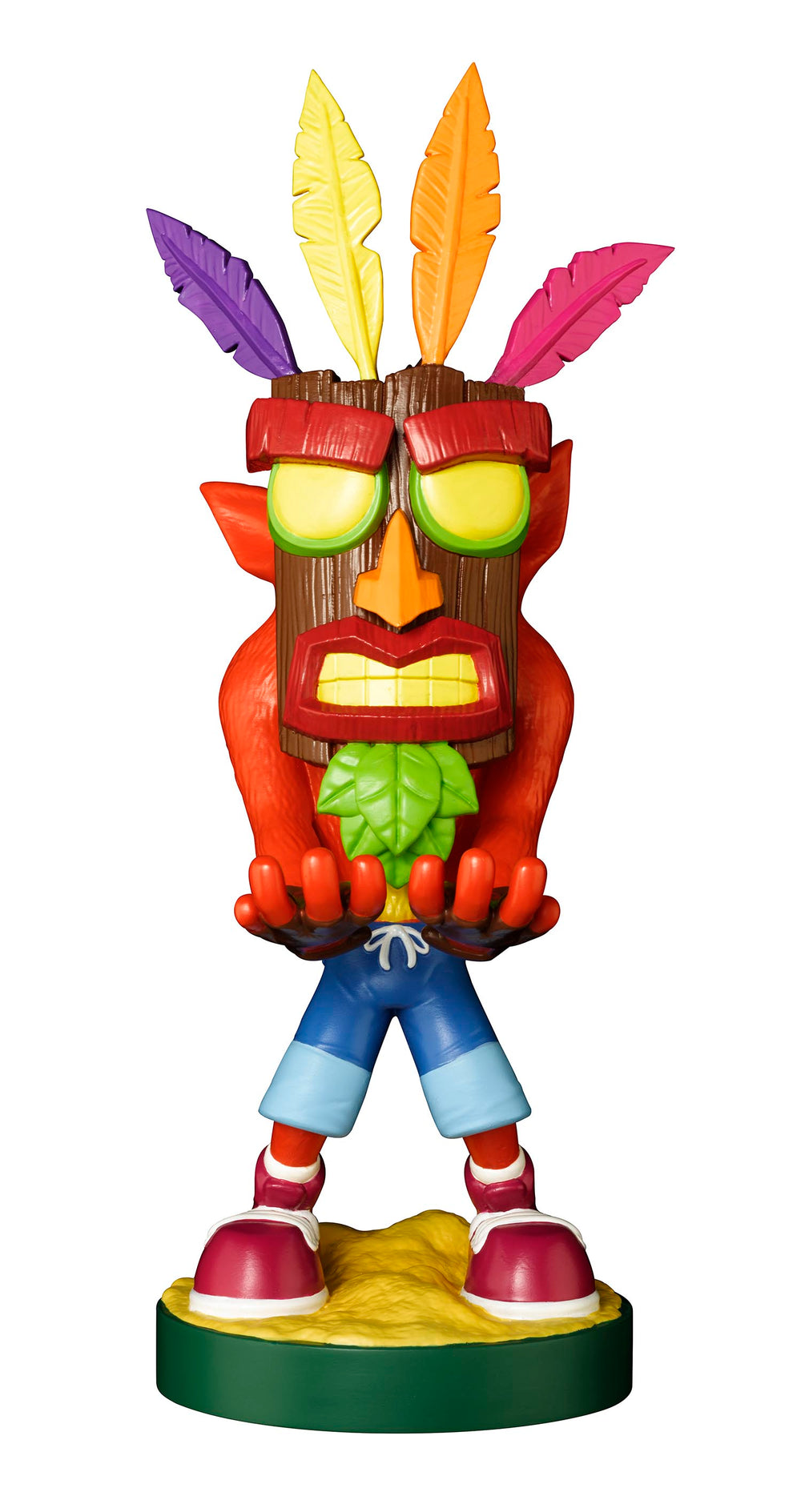 Aku Aku mask character figure with colorful feathers, red body, green mouth guard, blue pants, and red shoes on yellow and green base
